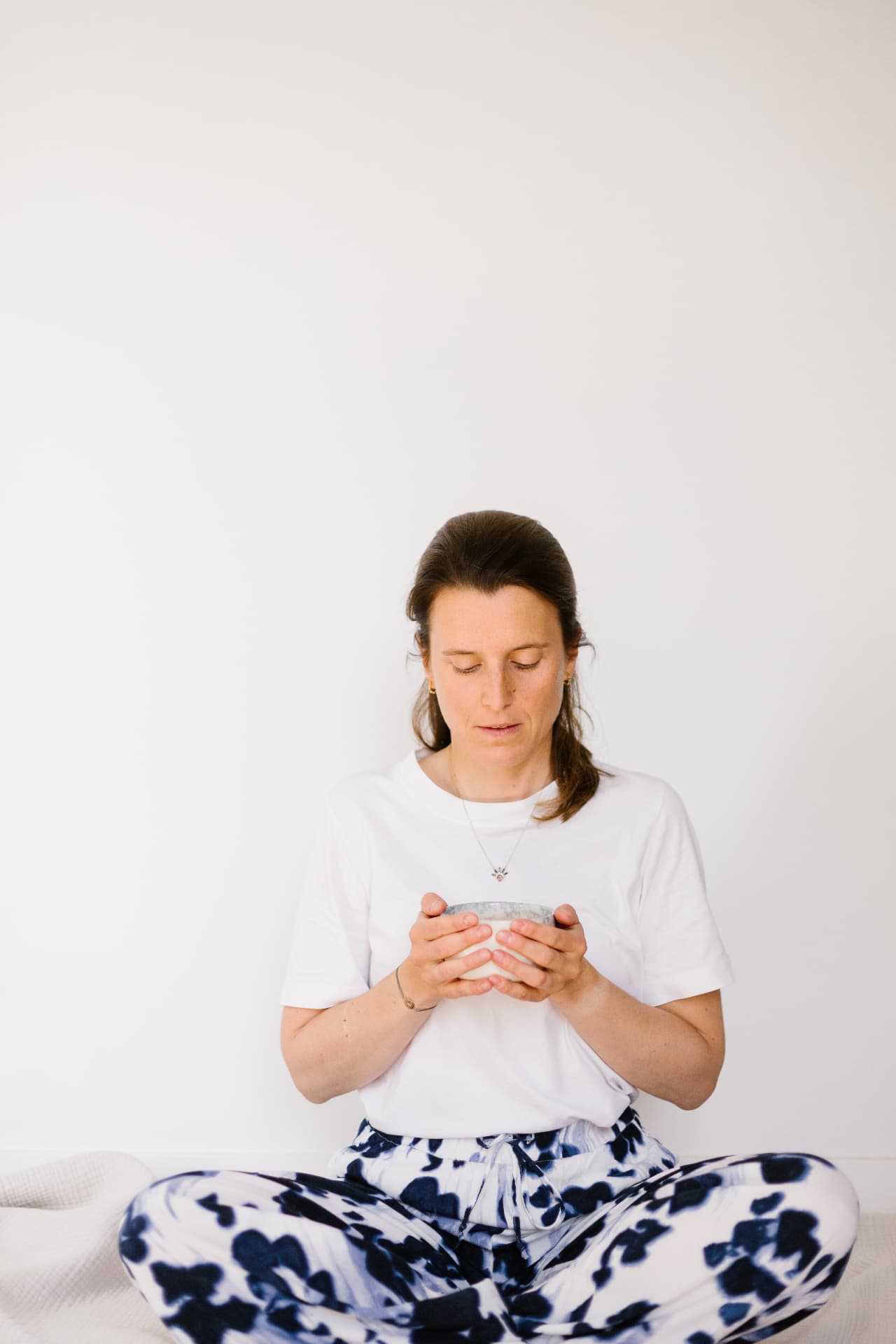 Hélène Cossée en méditation, tenant un bol entre ses mains