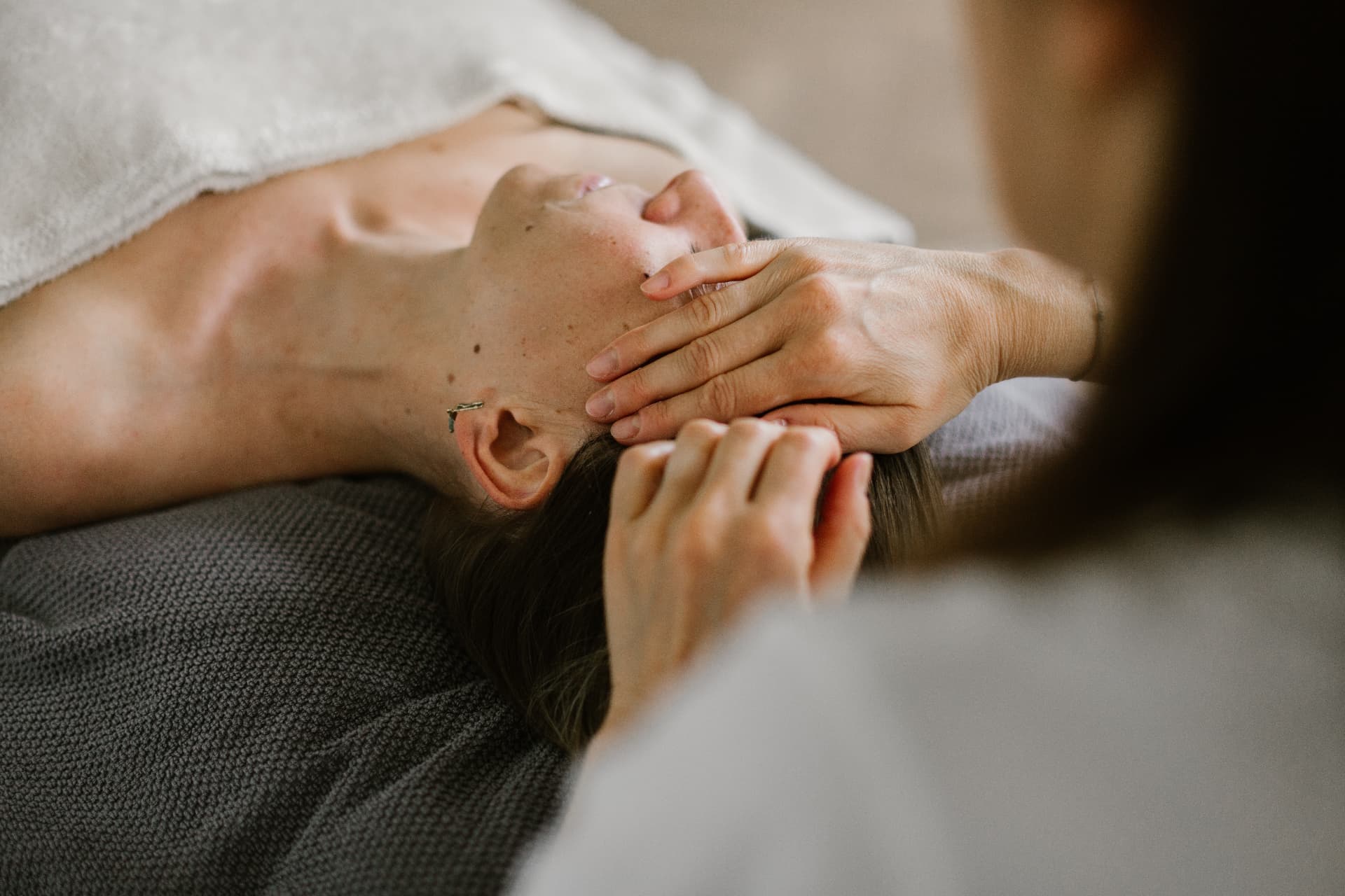 Mains posées sur le visage lors d'un soin
